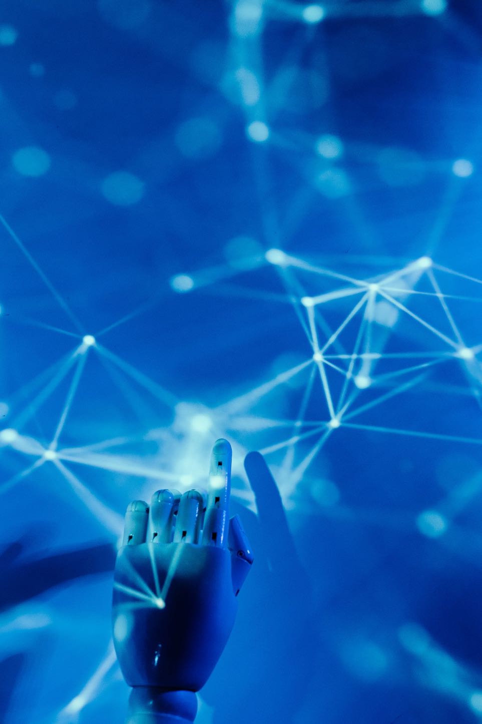 A white robotic hand reaching up towards a glowing blue network of connected points